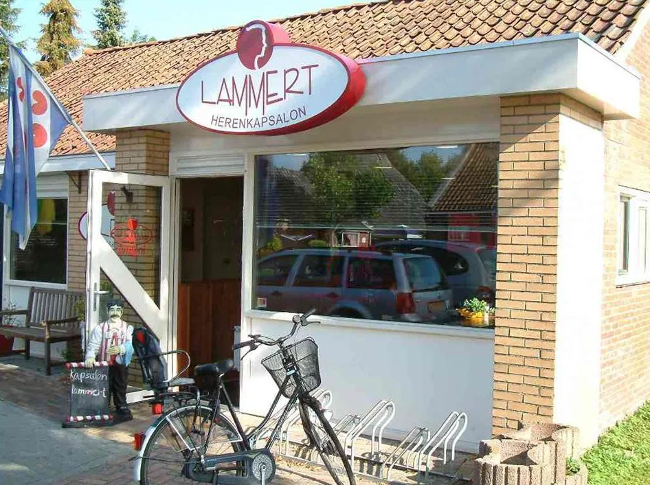 De gevel van de kapsalon met het rode uithangbord